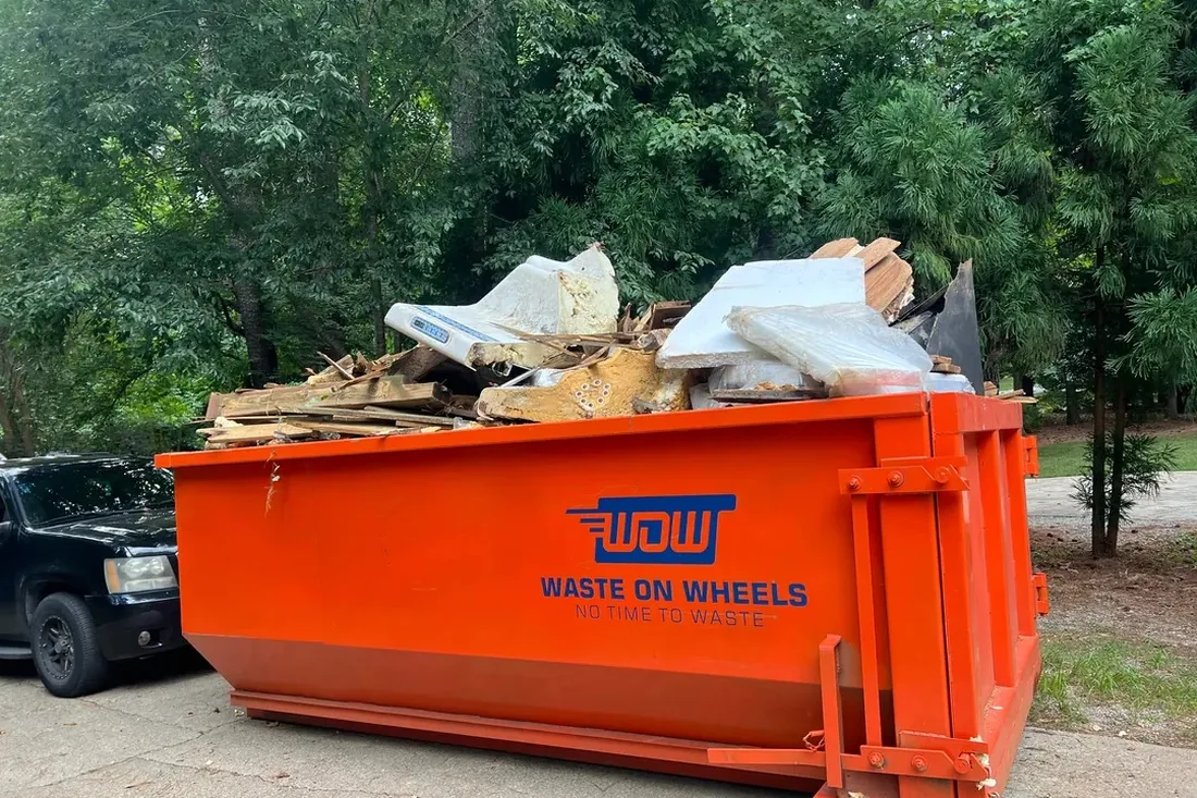 Waste On Wheels roll-off dumpster loaded with remodel debris in Fuquay-Varina, NC