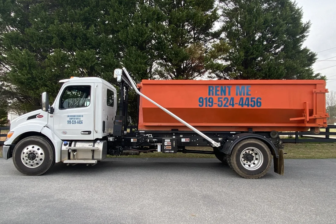 Roll-off dumpster positioned for a roof tear-off in Holly Springs, NC